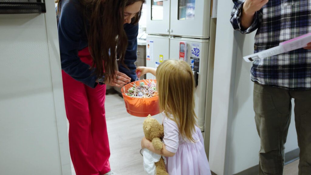 Sapphire Pediatrics team member offering a child a reward after a visit