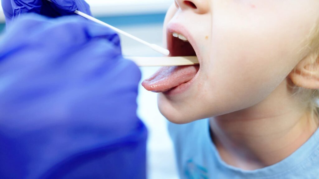 Care team member examining a child’s throat