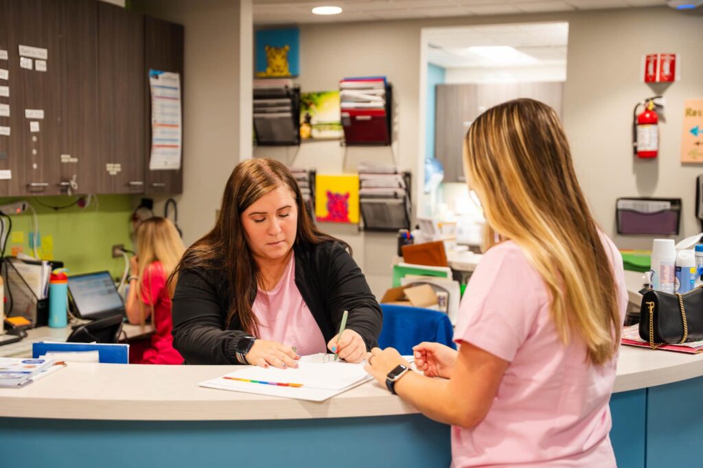 Two Sapphire Pediatrics team members working at reception