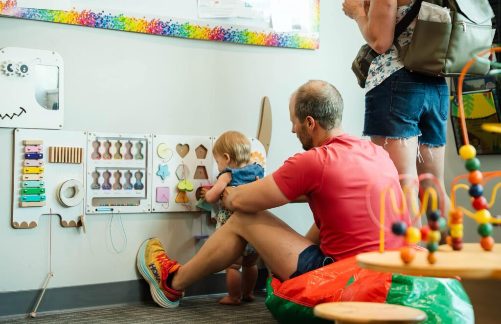 Adult and child using a sensory activity wall