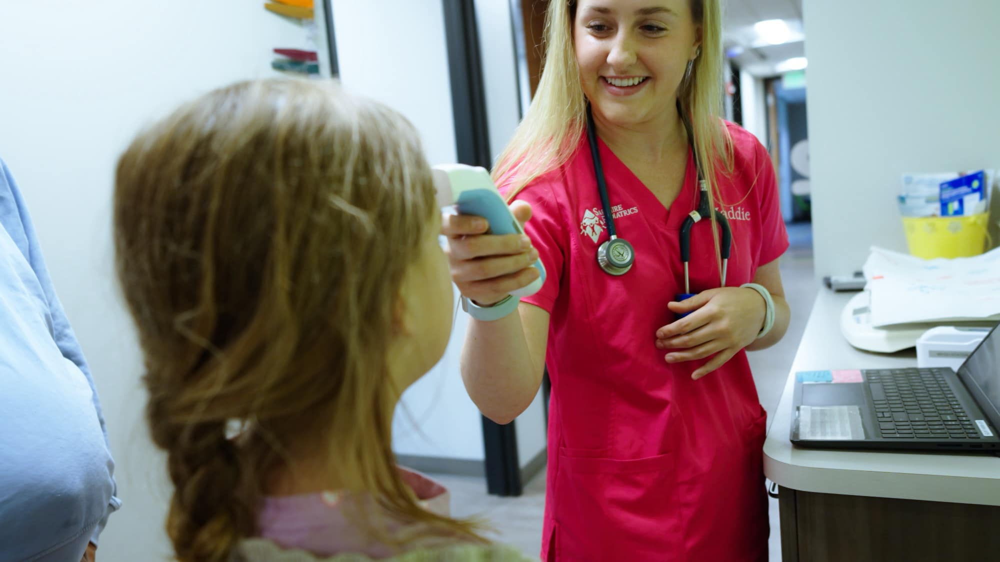 Sapphire Pediatrics team member checking a child’s temperature