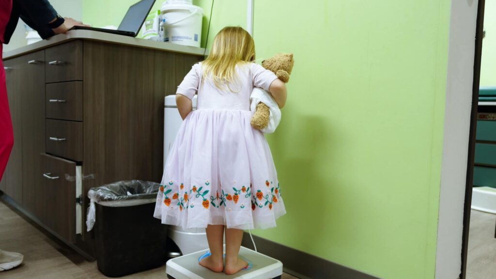 Child standing on a medical scale
