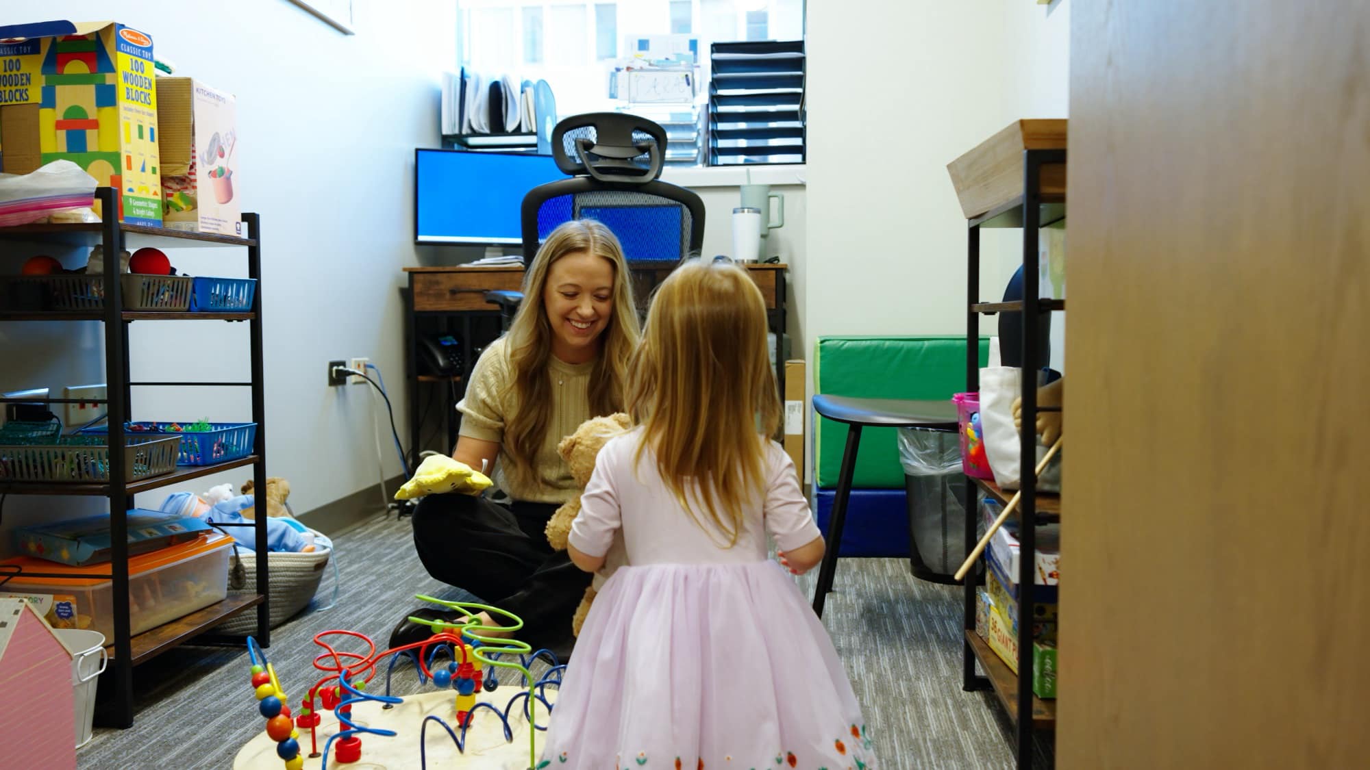 Care team member and child playing with toys